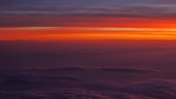 夕日の景色のオレンジ色の空に紫色の雲の上の飛行機からの眺め ハンドヘルド — ストック動画