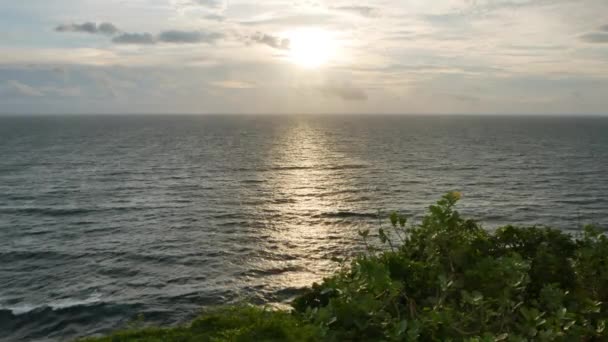 バリ島 インドネシア 1月22 2018 バリ島の前景にあるインド洋と緑の植物の上の景色の夕日 4Kワイドショット — ストック動画