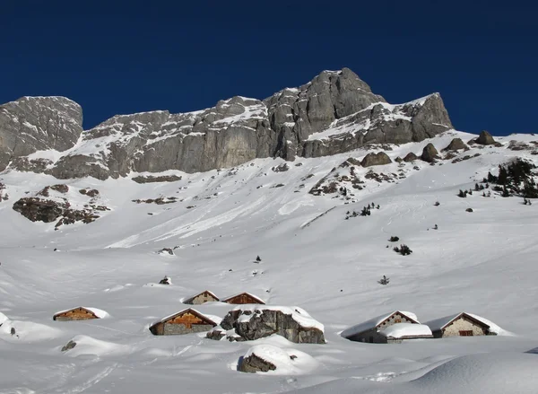 Snow covered huts and mountains — Stock Photo, Image