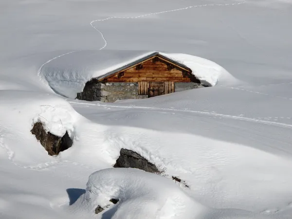 Rifugio in legno quasi completamente coperto di neve — Foto Stock