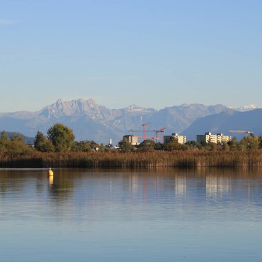 Wetzikon 'daki evler, Pfaeffikersee Gölü kıyıları ve dağ sıraları.