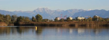 Wetzikon 'daki evler, Pfaeffikersee Gölü kıyıları ve dağ sıraları.