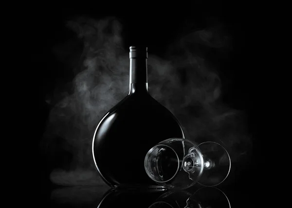 Garrafa e copo de vinho em fumaça no fundo preto — Fotografia de Stock