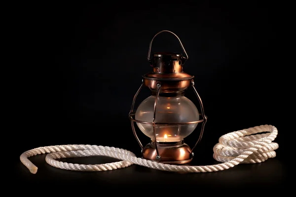 Old lamp and rope on black background — Stock Photo, Image