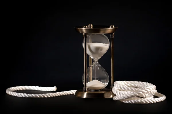 Sand clock and rope on black background — Stock Photo, Image