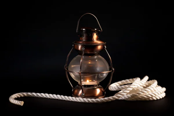 Old lamp and rope on black background — Stock Photo, Image