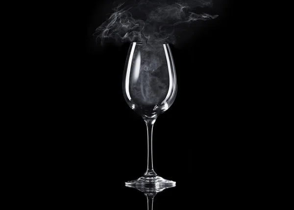 Empty glass of wine with smoke inside on black background — Stock Photo, Image