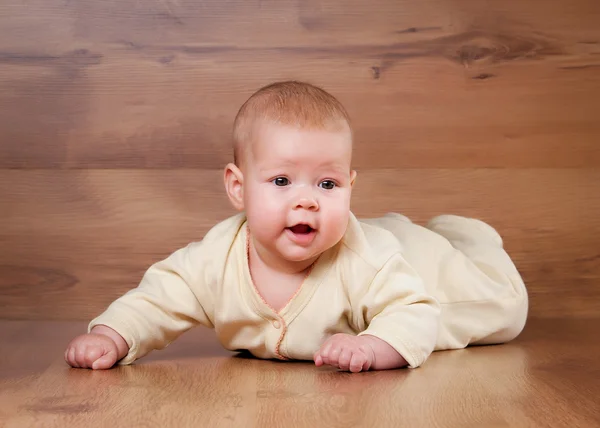 Pequeno bebê no fundo de madeira — Fotografia de Stock