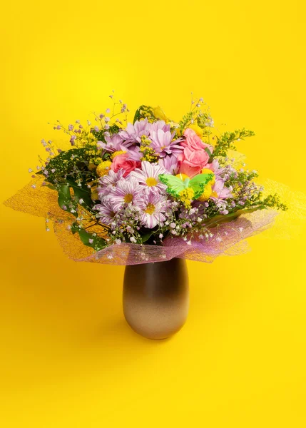 Bos van bloemen op gele achtergrond — Stockfoto