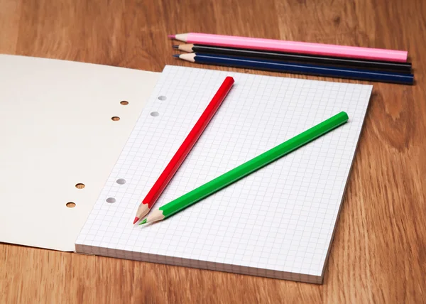 Pencils and notebook on wooden table — Stock Photo, Image