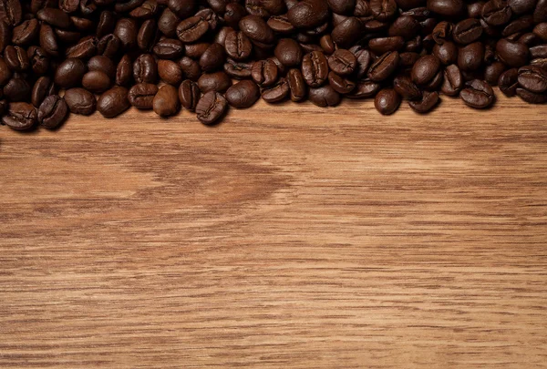 Rostade kaffebönor på trä textur — Stockfoto