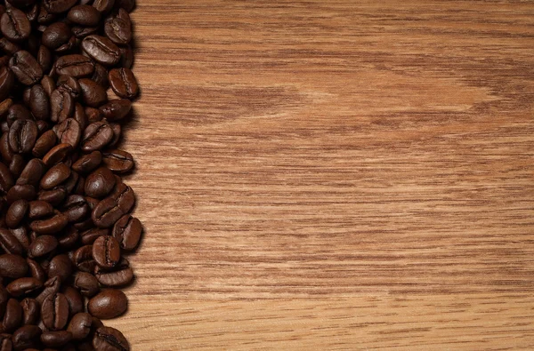 Roasted coffee beans on wooden texture — Stock Photo, Image