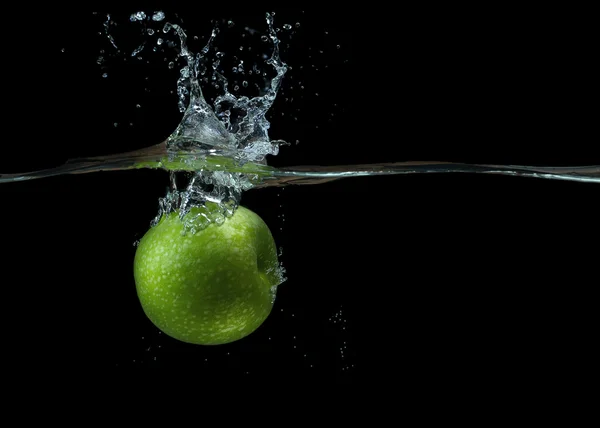 Grönt äpple i vatten med stänk och droppar — Stockfoto