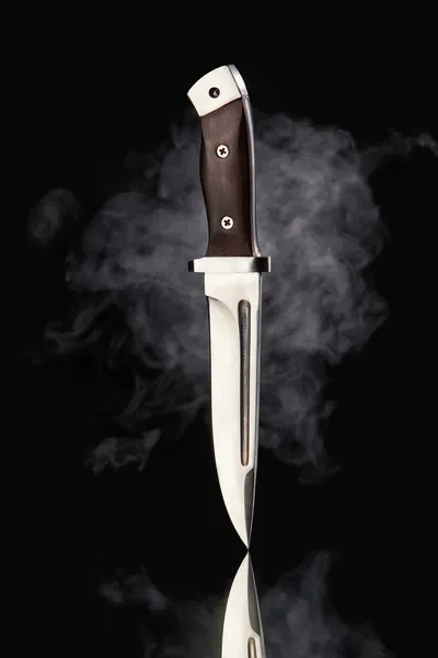 Cuchillo de caza con humo sobre fondo negro Imágenes de stock libres de derechos