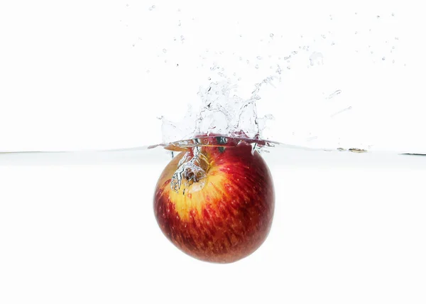 Apple spustil do vody stříkající na bílém pozadí — Stock fotografie