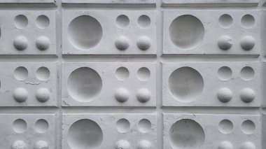 Beyaz duvar kabartması. Yuvarlak elementlerle yıpranmış duvar yüzeyi. Normal süslemeli tuğla duvar.