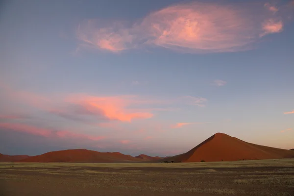 Puffy Pink Clouds over Red sand dunes — Stock Photo, Image