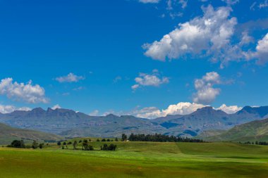 Green pastures and blue sky at the foothills of the mountain Drakensberg South Africa