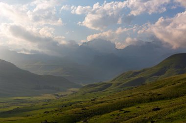 Akşam üstü Drakensberg 'in yeşil vadisinde bulutlar