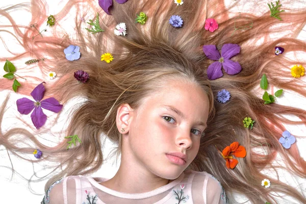 ゆったりとした髪の花を持つ美しい少女の感情的な肖像画 ロイヤリティフリーのストック画像