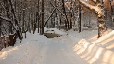 During the accident, the car drove off a slippery winter road. A broken car after an accident in a snowdrift. The driver lost control of the car on a slippery road in icy conditions