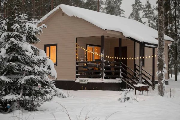 wooden house with snow on the roof against a gray sky in the snow. architecture of buildings. High-quality photo of a house under construction in the forest