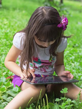 Kız çayırda tablet pc ile