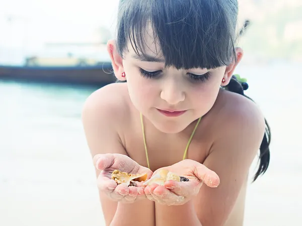 Flicka anläggning seashell — Stockfoto