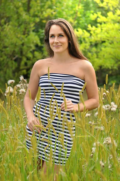 A beautiful young woman is happy in the grass — Stock Photo, Image