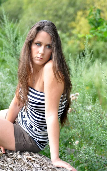 Beautiful woman sitting on meadow — Stock Photo, Image