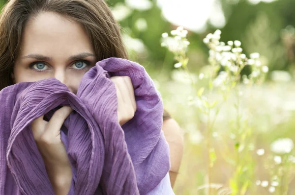 Retrato de uma mulher bonita com olhos azuis e um lenço roxo Fotografias De Stock Royalty-Free