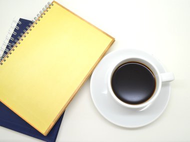 Notebook ve beyaz zemin üzerine kahve