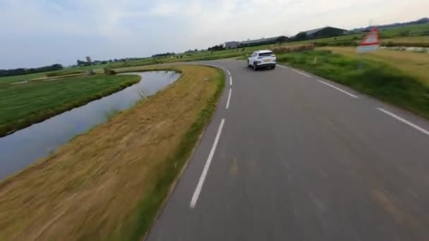 Naar aanleiding van een personenauto vervoer rijden door het platteland fpv luchtfoto drone view. — Stockvideo