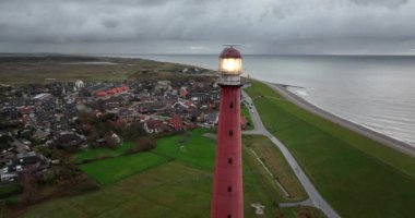 Den Helder 'de deniz feneri kulesi Lange Jaap. Hollanda, Kuzey Hollanda' daki Texel adası yakınlarında deniz boyunca 5K hava aracı görüntüsü..