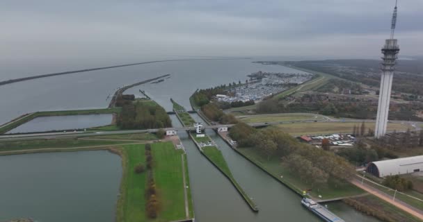 Houtribsluizen langs de dijk en de weg tussen Lelystad en Enkhuizen. Nederlandse infrastructuur langs het water Makermeer en Ijselmeer — Stockvideo