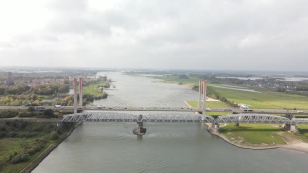 Dr W. Hupkesbrug i Martinus Nijhoffbrug dron powietrzny widok most infrastruktury autostrady na dużej drodze wodnej w Holandii. Zaltbommel — Wideo stockowe