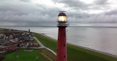 Den Helder 'de deniz feneri kulesi Lange Jaap. Hollanda, Kuzey Hollanda' daki Texel adası yakınlarında deniz boyunca 5K hava aracı görüntüsü..