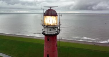 Den Helder 'de deniz feneri kulesi Lange Jaap. Hollanda, Kuzey Hollanda' daki Texel adası yakınlarında deniz boyunca 5K hava aracı görüntüsü..