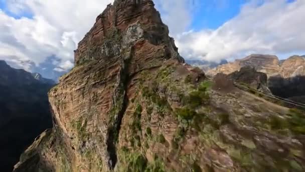Wunderschöne FPV-Drohnen-Luftaufnahme aus dem Gebirge, die an den Klippen Madeiras entlangfliegen. Actionsport beim Wandern durch die Wolken. Sonniger Tag. — Stockvideo