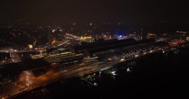 Imagens aéreas do horizonte do centro da cidade de Amsterdã os ferries e estação central à noite. — Vídeo de Stock