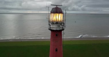 Den Helder 'de deniz feneri kulesi Lange Jaap. Hollanda, Kuzey Hollanda' daki Texel adası yakınlarında deniz boyunca 5K hava aracı görüntüsü..