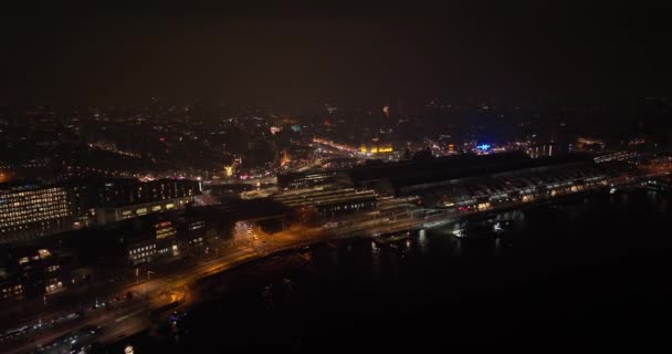Aerial footage of the skyline of Amsterdam city center the ferries and central station at night. — Stock Video