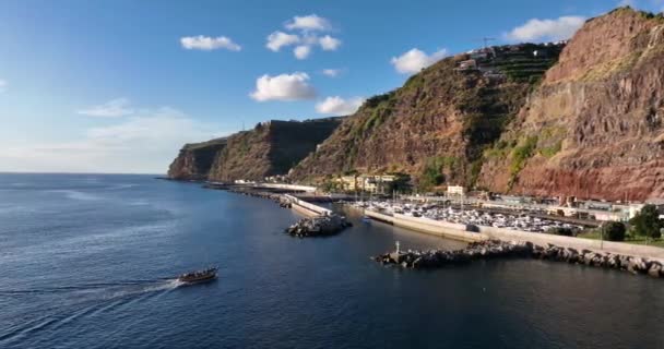 Coastline of Madeira Portugal beautifull sunny island the atlantic ocean aerial drone view. Aerial drone view. With a leisure vessel ship around the port. — Stock Video