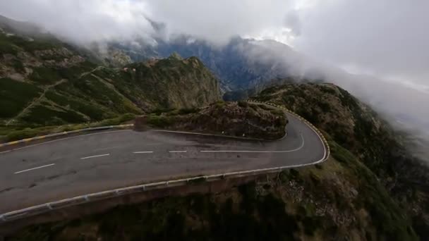 Ορειβασία πετώντας και καταδύοντας κατά μήκος ψηλών βράχων και βράχων σε μια κοιλάδα. FPV αγωνιστικά drone, Mountain δρόμο που φέρουν μέσα από τα σύννεφα. — Αρχείο Βίντεο