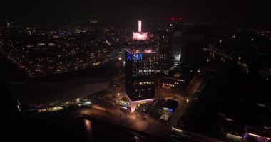 Amsterdam, 13 Kasım 2021, Hollanda 'da. Geceleri Amsterdam Gözcü Kulesi. Feribotlar kulenin yanında..