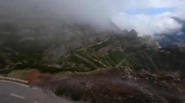 Dağ sörfü yapmak, yüksek uçurumlar ve kayalıklar boyunca bir vadiye dalmak. FPV yarış aracı, bulutların arasında uçan dağ yolu..