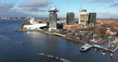 Amsterdam, 8 Aralık 2021, Hollanda. Amsterdam Gözcü Kulesi Film Müzesi ve gün batımında merkez istasyon hava aracı manzaralı feribot..