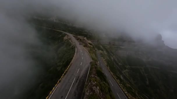 Surf de montagne volant et plongeant le long de hautes falaises et rochers dans une vallée. Drone de course FPV, Route de montagne volant à travers les nuages. — Video