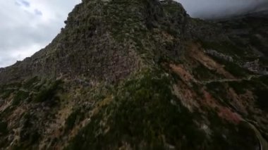 Dağ sörfü yapmak, yüksek uçurumlar ve kayalıklar boyunca bir vadiye dalmak. FPV yarış aracı, bulutların arasında uçan dağ yolu..