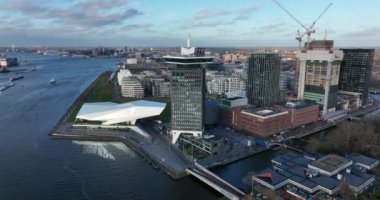 Amsterdam, 8 Aralık 2021, Hollanda. Amsterdam Gözcü Kulesi Film Müzesi ve gün batımında merkez istasyon hava aracı manzaralı feribot..